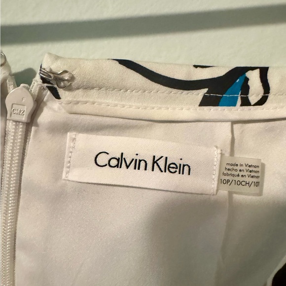 Teal blouse with teal and black highlights on a white skirt. - Picture 14 of 15